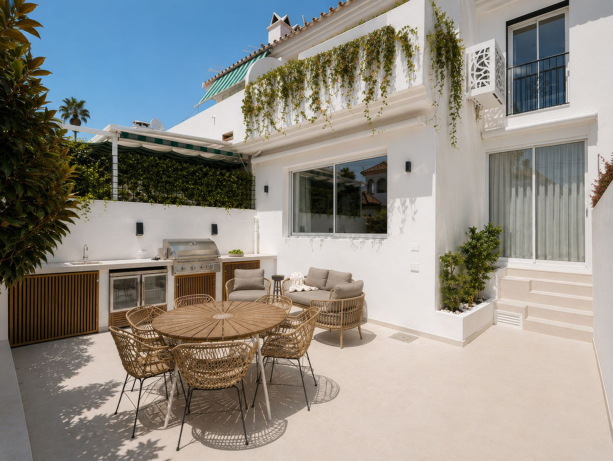 Outdoor kitchen with barbecue grill, wine cooler and round dining table for six on the private rear patio, San Pedro de Alcántara