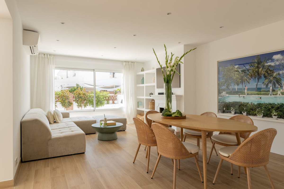 Open living and dining area with sofa, fireplace and dining table for six
