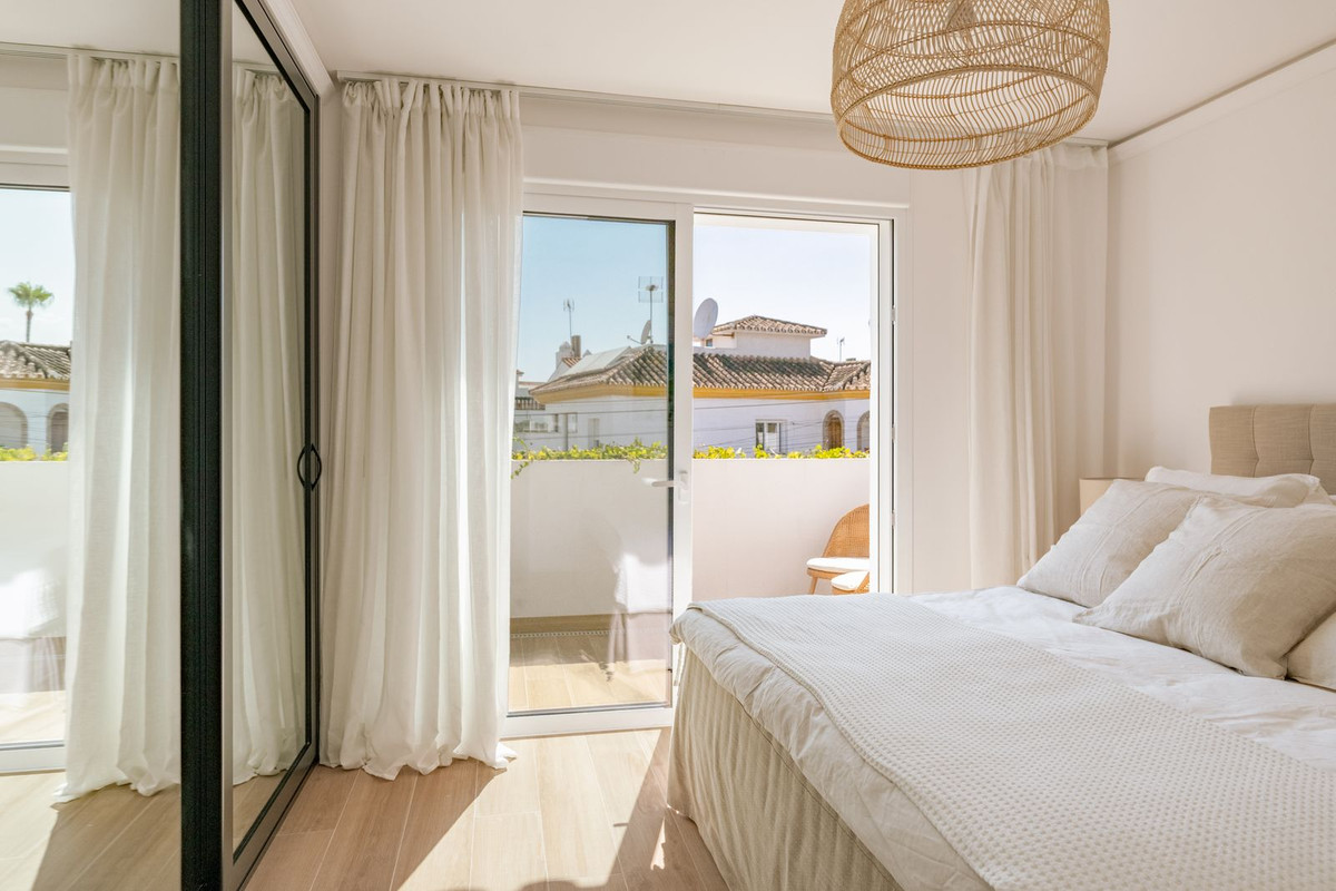 Bedroom with double bed and glazed door opening onto a balcony