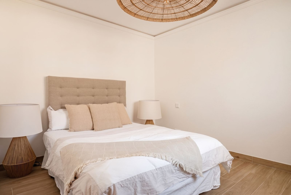 Bedroom with double bed and matching rattan bedside lamps