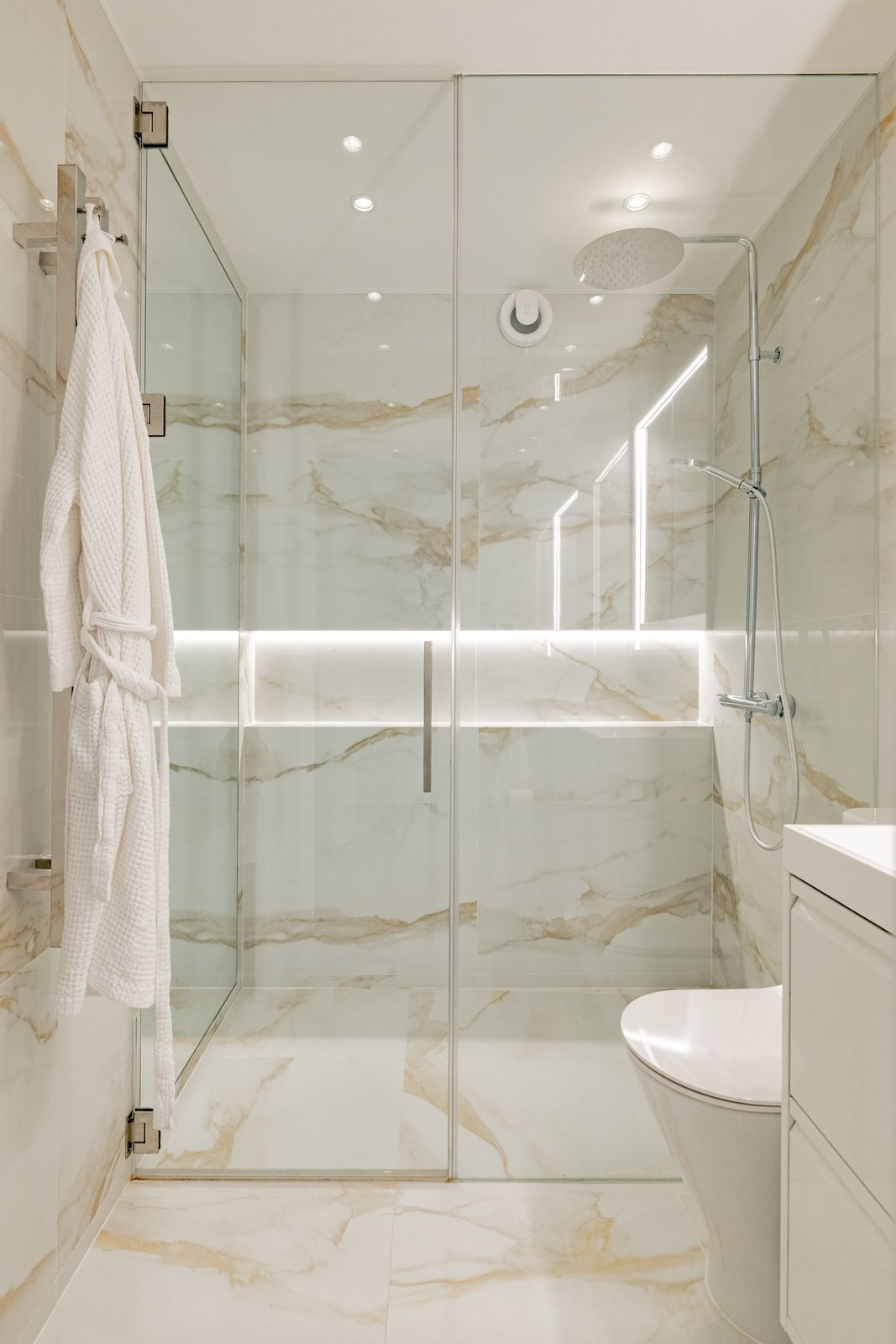 Marble shower corner with rain shower head and handheld shower on a slide rail