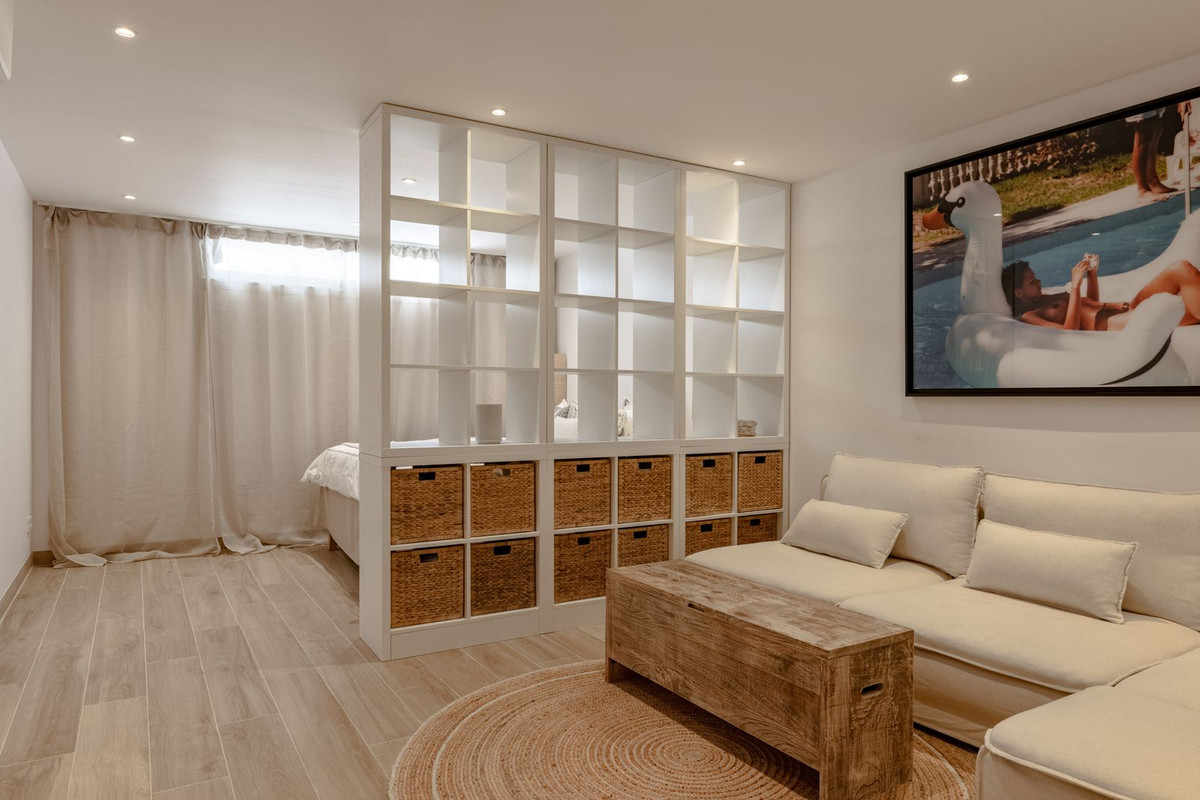 Fourth bedroom behind an open shelving divider, next to the lounge area